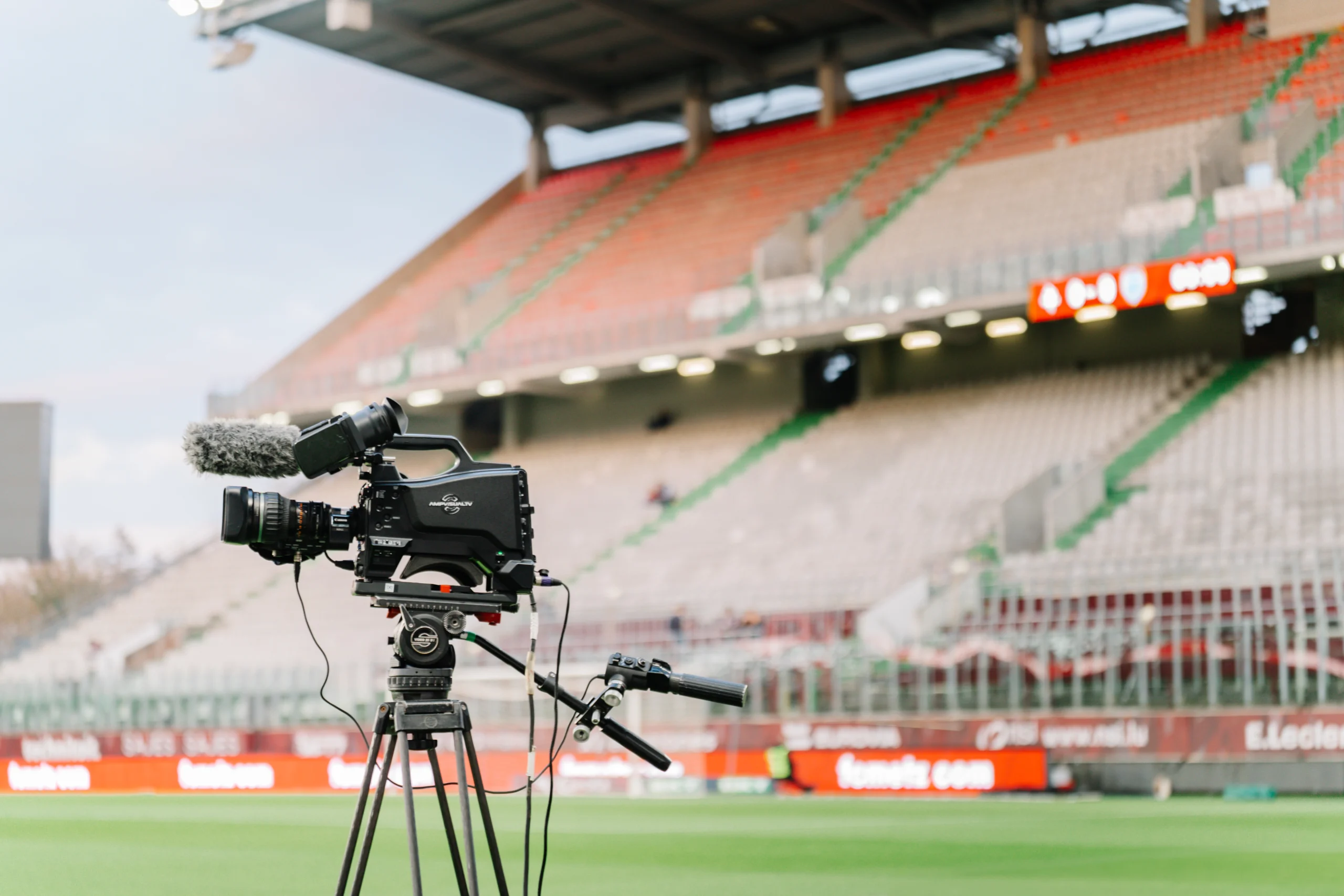 Caméra professionnelle filmant un match dans un stade de football – communication de presse et couverture médiatique