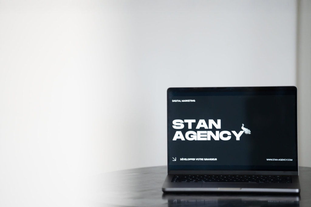 Ordinateur affichant un écran avec l’inscription « Stan Agency » – création de site web professionnel et développement digital sur mesure