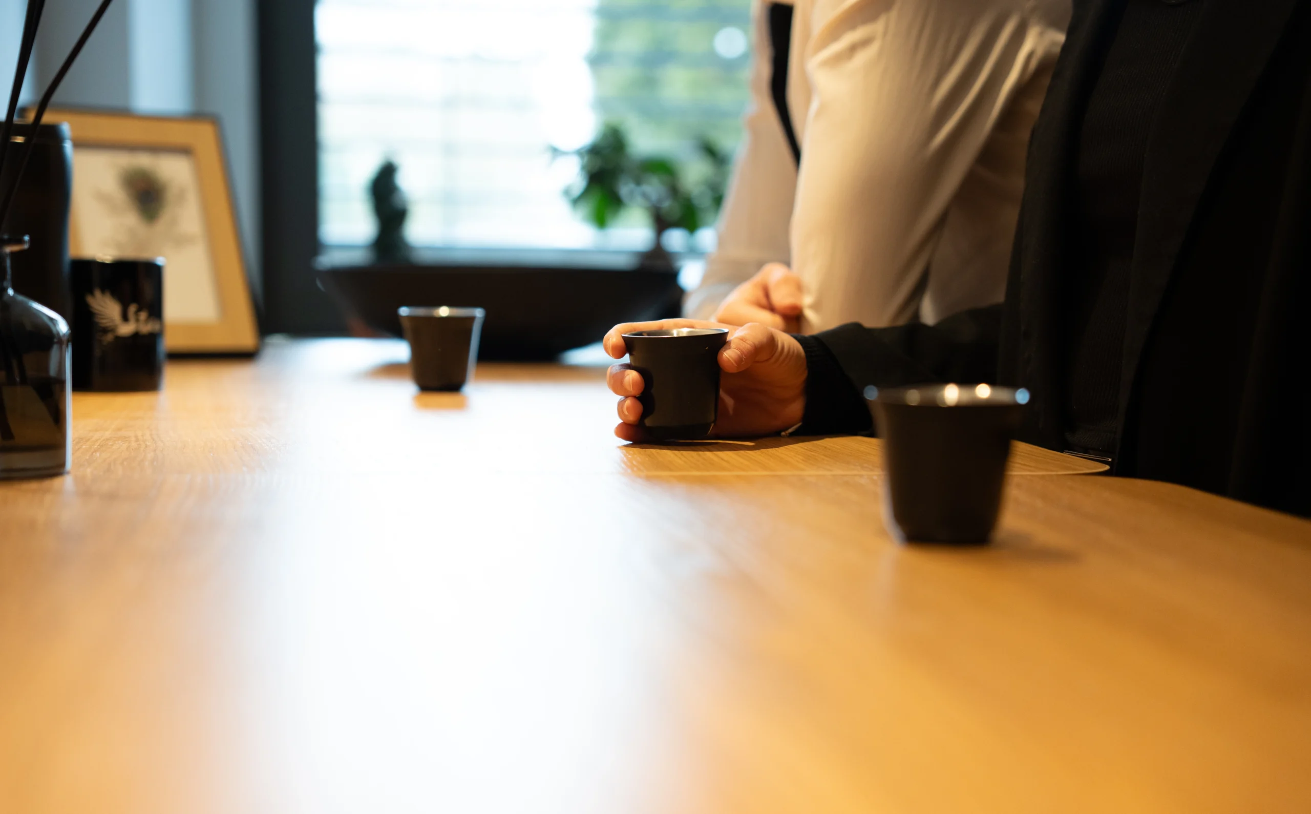 Collègues échangeant autour d’un café dans un cadre de travail paisible – Stan Agency, spécialiste du marketing d’influence et des stratégies collaboratives