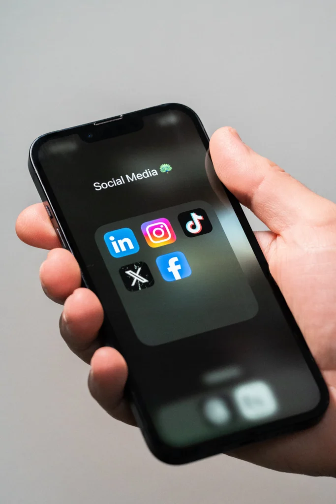 Téléphone affichant les icônes de plusieurs réseaux sociaux – Stan Agency, expert en community management et animation de communautés en ligne