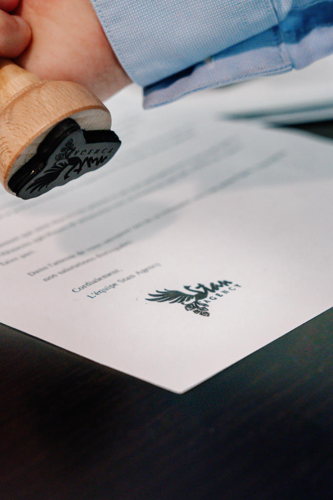 Tampon avec le logo Stan Agency apposé sur un document – recrutement de l’agence de marketing digital.